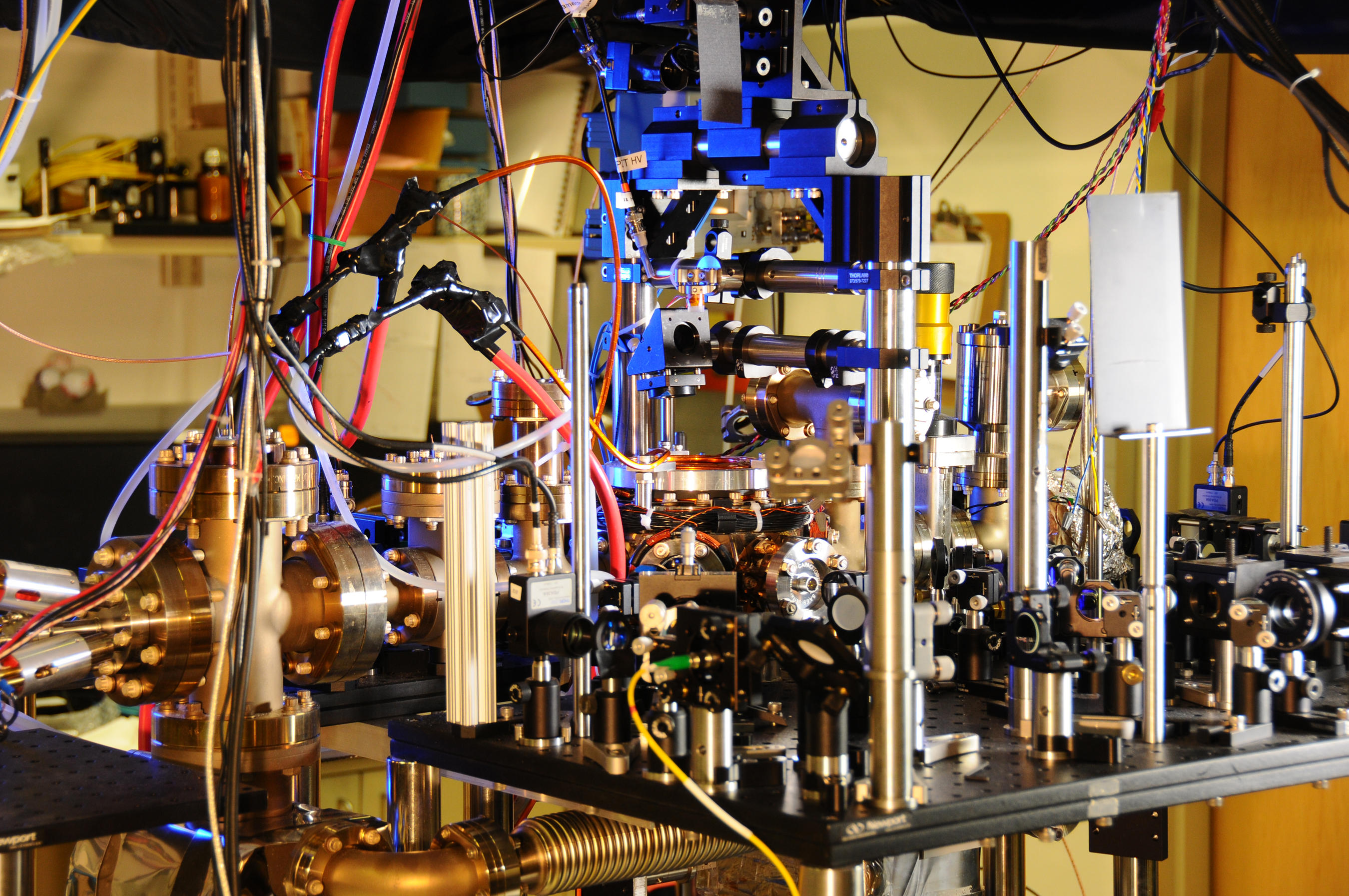 Metal vacuum chambers, optical components, and colored fiber cables in NIST's ytterbium optical lattice atomic clock laboratory.