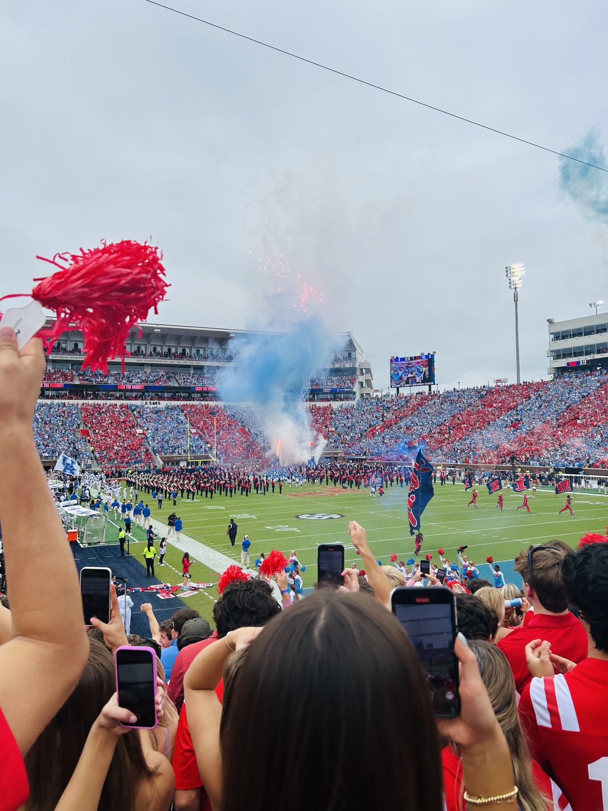 Ole Miss supporters raise red pom-poms as the team enters a packed Vaught-Hemingway Stadium.