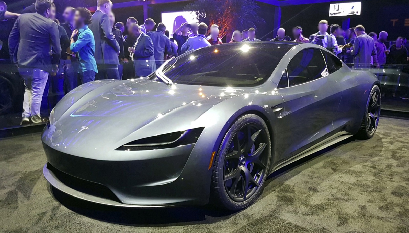 Silver Roadster prototype viewed from the front left, with visitors behind a barrier.